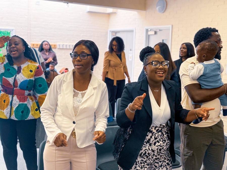 Members clapping and singing together during worship