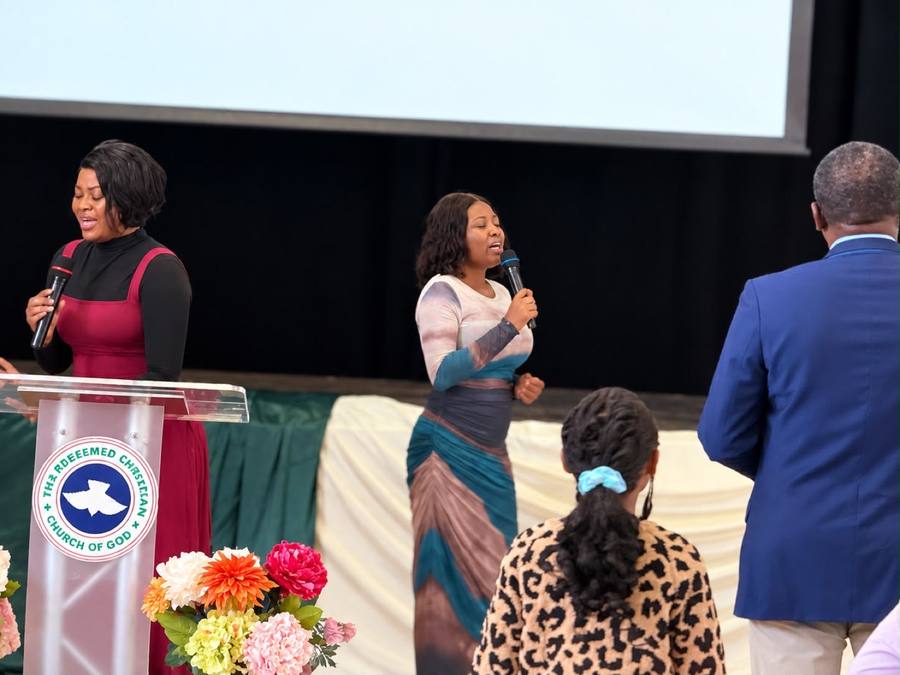 Two members speaking at the podium during a church event